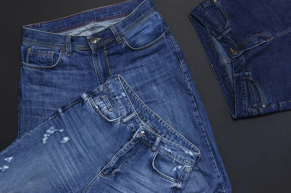 Conjunto de jeans azuis masculinos e femininos em fundo preto vista superior flat lay. Detalhe de jeans azuis agradáveis. Textura de calça ou fundo de ganga. Roupa de tendência. Beleza e moda, conceito de vestuário . — Fotografia de Stock