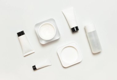 Beyaz kozmetik şişe konteynırları üzerine açık renkli düz lay görüntüleyin. Marka mock-up, doğal organik güzellik ürün kavramı, minimalizm kozmetik tarzı kozmetik Spa