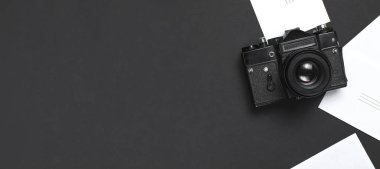 Eski retro vintage fotoğraf makinesi, en iyi görünüm düz siyah arka plan üzerinde beyaz boş fotoğraf kartları kopya alanı ile yatıyordu. Fotoğrafçı, eski fotoğrafik donanımlar, minimalist tarzı seçici odak için kavram