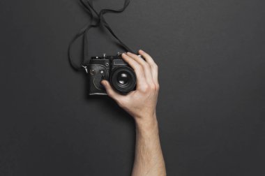 Eski vintage fotoğraf makinesi siyah arka plan en iyi görünüm düz kopya alanı ile yatıyordu erkek elele tutuşun. Fotoğrafçı, eski fotoğrafik donanımlar, minimalist tarzı için kavram