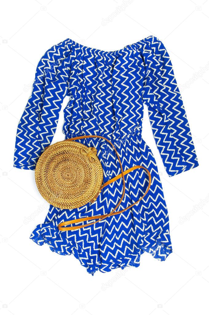 Stylish trendy feminine summer clothing blue dress jumpsuit, round rattan bag on white background Trendy hipster look Female fashion background blog concept Flat lay top view