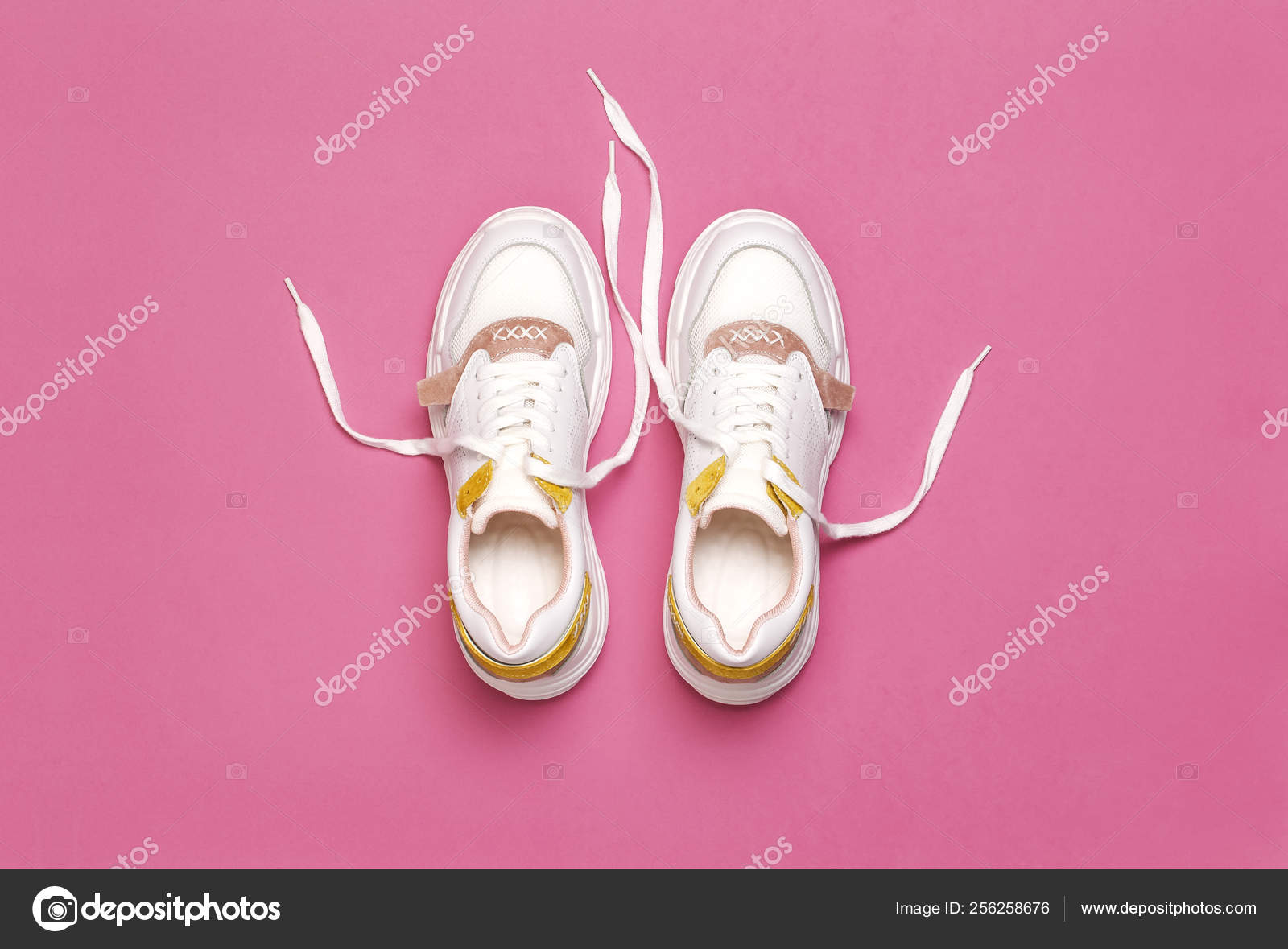 White female sneakers on bright pink 