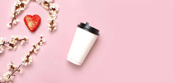 Kawa lub herbata kubek papieru, w kształcie serca ciasta makaronik, wiosna oddziałów białych kwiatów na różowym tle góry widok płaski lay. Zabrać filiżankę kawy, makieta. Koncepcja miłości kawy, układ do projektowania — Zdjęcie stockowe