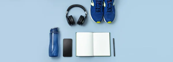 Mannen Blue Sneakers, fles water, smartphone, koptelefoon, notebook dagboek met marker op blauwe achtergrond bovenaanzicht platte lay kopie ruimte. Concept van een actieve levensstijl, sport, fitness, gezondheid — Stockfoto