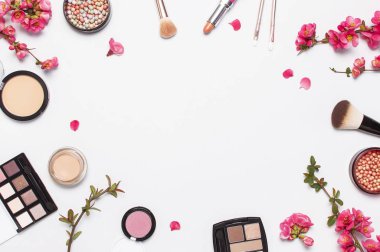 Farklı makyaj kozmetik. Ball allık rouge yüz pudra ruj kapatıcı şişe parfüm göz farı makyaj fırça bahar pembe çiçekler açık arka plan üst görünümü düz yatıyordu. Güzellik moda arka plan