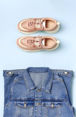 Mavi denim ceket ve mavi arka plan üst görünüm düz üzerinde trendy pembe spor ayakkabıları kopyalama alanı yatıyordu. Denim, moda ceket kadın veya erkek trend giyim, moda güzellik arka plan. Bahar Moda Konsepti