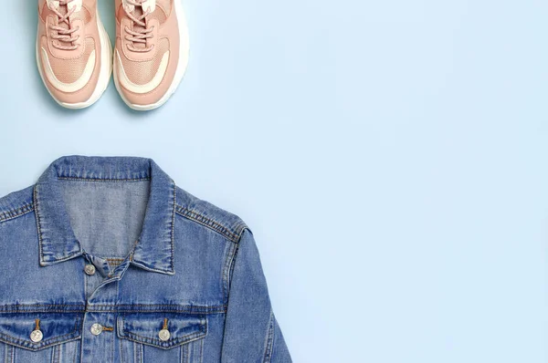 Μπλε ντένιμ μπουφάν και μοντέρνα ροζ αθλητικά παπούτσια σε μπλε φόντο πάνω θέα επίπεδη χώρο θέσει αντίγραφο. Βαμβακερό denim, μόδας σακάκι γυναικεία ή ανδρικά ρούχα τάσης, στυλ ομορφιάς φόντο. Ανοιξιάτικη ιδέα της μόδας — Φωτογραφία Αρχείου