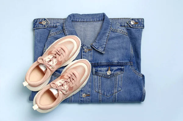 Mavi denim ceket ve mavi arka plan üst görünüm düz üzerinde trendy pembe spor ayakkabıları kopyalama alanı yatıyordu. Denim, moda ceket kadın veya erkek trend giyim, moda güzellik arka plan. Bahar Moda Konsepti