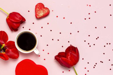 Kırmızı laleler, kırmızı kalp şeklinde hediye kutusu, kahve fincanı, makarna kek, pastel pembe arka plan üst görünümü Düz konfeti yatıyordu. Anneler Günü Sevgililer Günü doğum günü tatil arka plan. Güzel tebrik kartı