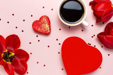 Kırmızı laleler, kırmızı kalp şeklinde hediye kutusu, kahve fincanı, makarna kek, pastel pembe arka plan üst görünümü Düz konfeti yatıyordu. Anneler Günü Sevgililer Günü doğum günü tatil arka plan. Güzel tebrik kartı