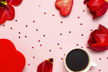 Kırmızı laleler, kırmızı kalp şeklinde hediye kutusu, kahve fincanı, makarna kek, pastel pembe arka plan üst görünümü Düz konfeti yatıyordu. Anneler Günü Sevgililer Günü doğum günü tatil arka plan. Güzel tebrik kartı