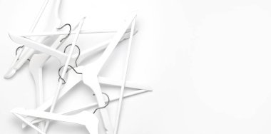 Düz yatıyordu üst görünüm Beyaz ahşap askıları beyaz arka plan kopyalama alanı minimalizm tarzı. Satılık indirim mağaza alışveriş konsepti, tasarım boş askı. Yaratıcı moda güzellik kadınsı blog