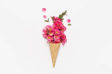 Hafif arka planda pembe bahar çiçekleri buketi ile Waffle konisi. Yaratıcı bahar minimal kavramı. Düz lay üst görünüm kopyalama alanı. İlkbahar veya yaz ruh hali kavramı