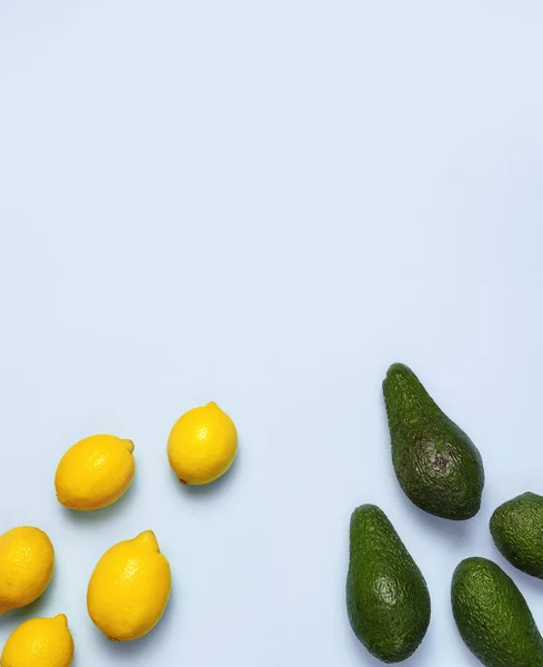 Ripe fresh avocado and fresh citrus lemons on pastel blue background top view Flat lay copy space. Fruits Healthy food concept, diet, healthy lifestyle.