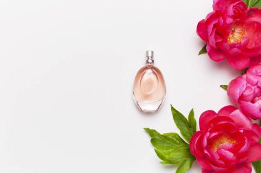 Parfüm şişesi ve pembe çiçekler şakayık açık gri arka plan üst görünüm Düz kopyalama alanı yatıyordu. Parfümeri, kozmetik, kadın aksesuarları, koku koleksiyonu. Narin Pembe Parfüm Şişesi