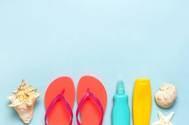 Yaz plaj deniz aksesuarları. Mercan parmak arası terlik, kabukları, denizyıldızı, sarı güneş kremi şişesi, mavi arka plan üst görünüm düz vücut spreyi kopyalama alanı yatıyordu. Yaz arka plan Tatil tatil seyahat konsepti