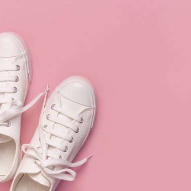 Pembe arka planda beyaz kadın moda ayakkabıları. Düz konum, üst görünüm, kopyalama alanı. Kadın ayakkabıları. Şık beyaz ayakkabılar. Moda blogu ya da dergi konsepti. Minimalist ayakkabı arkaplanı, spor ayakkabıları