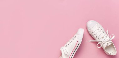 Pembe arka planda beyaz kadın moda ayakkabıları. Düz konum, üst görünüm, kopyalama alanı. Kadın ayakkabıları. Şık beyaz ayakkabılar. Moda blogu ya da dergi konsepti. Minimalist ayakkabı arkaplanı, spor ayakkabıları