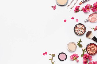 Farklı makyaj kozmetik. Ball allık rouge yüz pudra ruj kapatıcı şişe parfüm göz farı makyaj fırça bahar pembe çiçekler açık arka plan üst görünümü düz yatıyordu. Güzellik moda arka plan