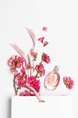 Pembe bahar çiçekleri ile kadın parfüm şişesi beyaz hediye paketi hafif arka plan üst görünüm düz metin kopya alanı yatıyordu. Parfümeri kozmetik kadın aksesuarları koku koleksiyonu. Pembe Parfüm