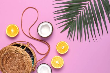 Yaz moda düz yatıyordu. Yuvarlak trendy rattan çanta, tropikal palmiye yaprakları, canavar yaprağı, hindistan cevizi, pembe arka plan üzerinde turuncu. Üst görünüm, kopyalama alanı. Modaya uygun bambu çanta. Yaratıcı arka plan, tatil konsepti