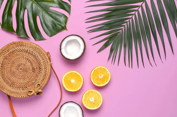 Verano de moda plana laico. Bolsa de ratán de moda redonda, hojas de palma tropical, hoja de monstruo, coco, naranja sobre fondo rosa. Vista superior, espacio de copia. Bolso de bambú de moda. Fondo creativo, concepto de vacaciones — Foto de Stock