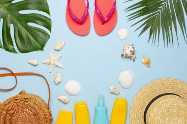 Yaz kompozisyon düz yatıyordu. Yuvarlak trendy Rattan çanta saman şapka mercan Flip flop tropikal palmiye mavi arka plan üzerinde Hindistan cevizi güneşliği deniz kabuğu yaprakları. Üst görünüm kopya alanı. Yaratıcı moda zemin
