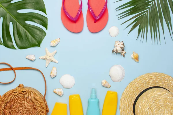 Summer composition flat lay. Round trendy rattan bag straw hat coral flip flops tropical palm leaves coconut sunscreen seashells on blue background. Top view copy space. Creative fashion backdrop — Stock Photo, Image