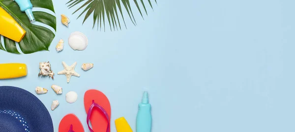 Verano de moda plana laico. Sombrero azul chanclas de coral palma tropical hojas protector solar conchas marinas sobre fondo azul. Espacio de copia de vista superior. Fondo de vacaciones de moda creativa — Foto de Stock
