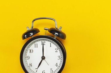 Sarı arka plan en iyi görünüm düz siyah retro çalar saat kopya alanı yatıyordu. Minimalist arka plan, zaman, son tarih, çalışmak için zaman, sabah kavramı