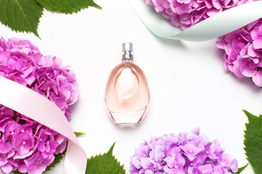 Parfüm şişesi, pembe ortanca çiçekler, hafif arka plan üst görünüm Düz tatil şeritler kopyalama alanı yatıyordu. Parfümeri, kozmetik, kadın aksesuarları, koku koleksiyonu. Hassas Parfüm Şişesi