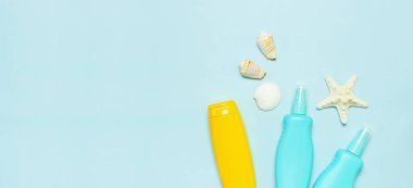 Yaz konsepti, deniz geçmişi. Deniz kabukları, denizyıldızı, pastel mavi arka plan üzerinde güneş kremi vücut kremi sprey. Üst görünüm, düz döşeme, kopyalama alanı. Deniz yaz tatili Mockup. Seyahat, deniz hatırası