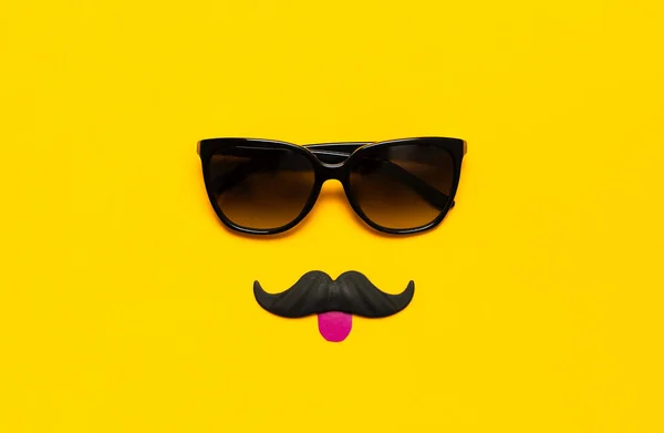 Conceito de decoração de festa criativa. bigode preto, óculos de sol, adereços para cabines de fotos, festas de carnaval no fundo amarelo vista superior plana leigos espaço de cópia. Dia do pai, mês de conscientização da saúde dos homens — Fotografia de Stock