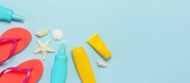 Yaz plaj deniz aksesuarları. Mercan parmak arası terlik, kabukları, denizyıldızı, sarı güneş kremi şişesi, mavi arka plan üst görünüm düz vücut spreyi kopyalama alanı yatıyordu. Yaz arka plan Tatil tatil seyahat konsepti