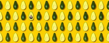 Olgun dilimlenmiş avokado desen sarı arka plan üstten görünüm. Yaratıcı yiyecekler kompozisyon düz yatıyordu. Pop sanat tasarım, tropikal yaz arka plan ile avokado. Yeşil avocadoes desen. Afiş