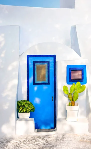 Porta azul velha bonita, janela azul na fachada branca da arquitetura grega e flores potted, ilha de Santorini, Greece, Europa. Belos detalhes da ilha de Santorini. Destino de viagem famoso — Fotografia de Stock