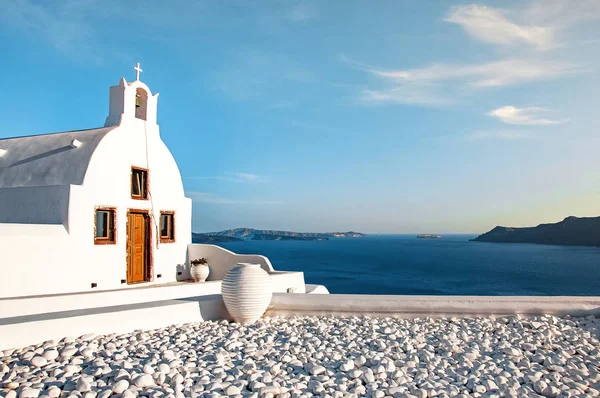 Hermosa vieja iglesia blanca contra el cielo azul y el mar Egeo azul. Oia, Santorini, Grecia, Europa. Clásica arquitectura griega blanca, casas, iglesias. Concepto de viaje, popular lugar romántico — Foto de Stock