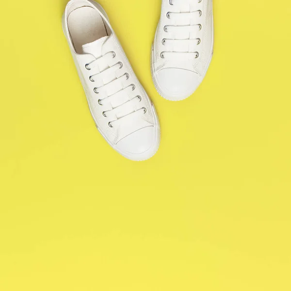 노란색 배경에 흰색 여성 패션 운동화입니다. 플랫 레이 탑 뷰 복사 공간. 여성 신발. 세련 된 화이트 스 니 커 즈. 패션 블로그 또는 잡지 컨셉. 미니멀 한 신발 배경, 스포츠 — 스톡 사진
