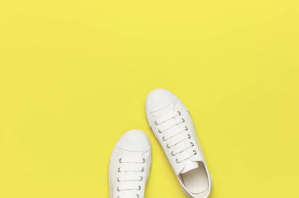 Fehér női divat cipők sárga háttérrel. Lapos feküdt felülnézet másolási tér. Női cipő. Stílusos fehér cipők. Fashion blog vagy magazin koncepcióját. Minimalista cipő háttér, sport — Stock Fotó