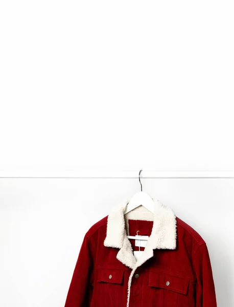 Червоний кордуровий чоловічий піджак на вішалці для білого пальто на стрижні проти світлої стіни плоский простір для копіювання. Чоловіча мода, осіннє весняне пальто, молодіжний хіпстерський одяг стильна річ джинсова модна куртка, продаж магазину — стокове фото
