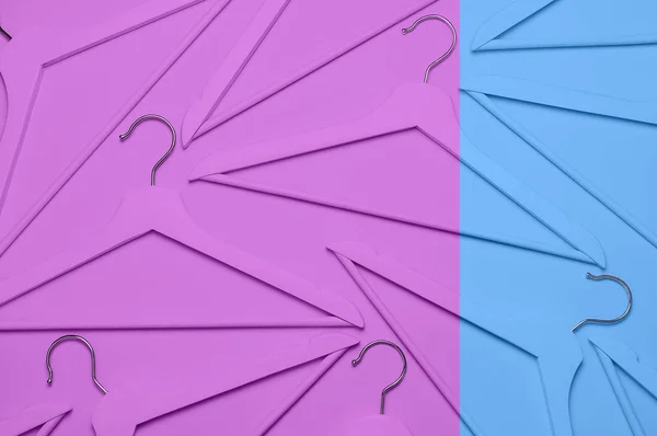 Conceito de moda criativa. Flat lay vista superior coloridos cabides de madeira no fundo azul rosa estilo pop-art minimalismo. Venda conceito de compras loja de desconto, design cabide vazio. Beleza blog feminino — Fotografia de Stock