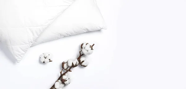 Miękkie białe pikowane poduszki i oddział bawełny na jasne tło widok z góry. Czyste poduszkę, element wnętrza, pościel makieta szablon projektu — Zdjęcie stockowe