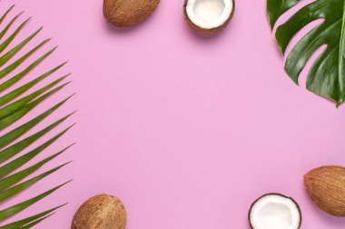 Pembe arka plan üzerinde tropikal yaprakları ve taze hindistan cevizi Çerçeve. Düz döşeme, üst görünüm, kopyalama alanı. Yaz geçmişi, doğa. Sağlıklı yemek pişirme. Yaratıcı sağlıklı gıda kavramı, hindistan cevizi yarısı