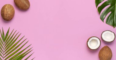 Pembe arka plan üzerinde tropikal yaprakları ve taze hindistan cevizi Çerçeve. Düz döşeme, üst görünüm, kopyalama alanı. Yaz geçmişi, doğa. Sağlıklı yemek pişirme. Yaratıcı sağlıklı gıda kavramı, hindistan cevizi yarısı