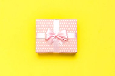 Hediye veya sarı arka plan üst görünümünde güzel festival kurdele ile mevcut kutu. Kutlama, tatil, doğum günü, Sevgililer Günü, 8 Mart, anneler günü, düğün için Düz yatıyordu kompozisyon. Kutlama