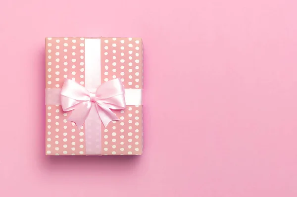 Regalo o scatola regalo con bellissimo nastro festivo su sfondo rosa vista dall'alto. Composizione laica piatta per celebrazione, vacanza, compleanno, San Valentino, 8 marzo, festa della mamma, matrimonio. Congratulazioni. — Foto Stock