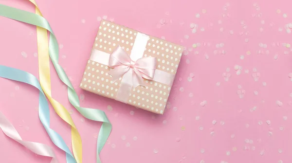 Confezione regalo o regalo, bellissimo nastro festivo, coriandoli su sfondo rosa vista dall'alto. Composizione laica piatta per celebrazione, vacanza, compleanno San Valentino 8 marzo festa della mamma, matrimonio. Congratulazioni. — Foto Stock