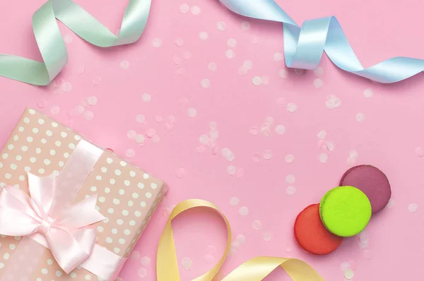 Geschenk-oder Geschenkbox schöne festliche Band Kuchen Macaron oder Makronen Konfetti auf rosa Hintergrund Draufsicht. flache Liegekomposition für Feiertage Geburtstag, Valentinstag, 8. März, Muttertag — Stockfoto