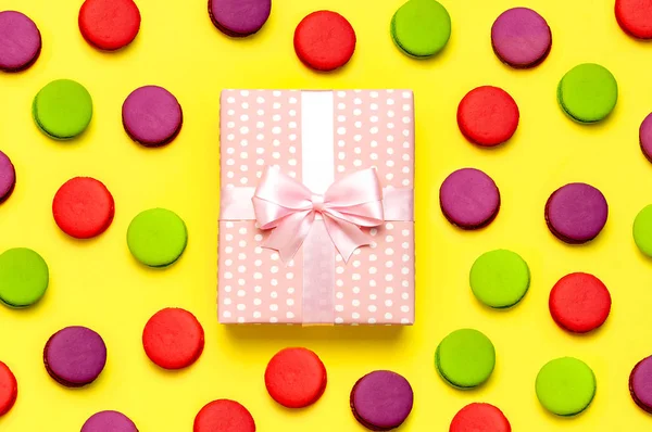 礼品或礼物盒，蛋糕马卡龙或马卡龙在黄色背景顶视图。创意平铺组成庆祝，节日，生日，情人节，3月8日，母亲节，婚礼 — 图库照片