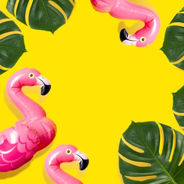 Yaratıcı yaz plaj konsepti. Şişme pembe mini flamingo ve sarı arka plan üzerinde tropikal yaprak monstera, havuz float parti. Düz döşeme kopya alanı. Flamingo Trend Şişme Oyuncak. Yaz arka planı